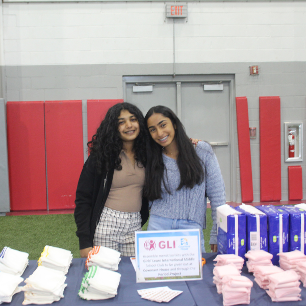 Girls behind a table full of period products.